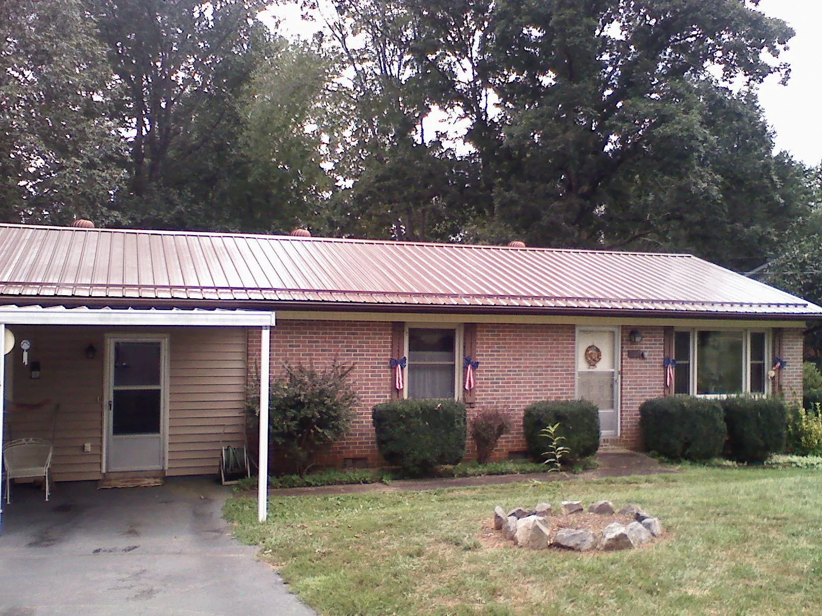 Bronze metal roof and carport on a brick ranch home — Roof Repair work by our crew in Sour Lake